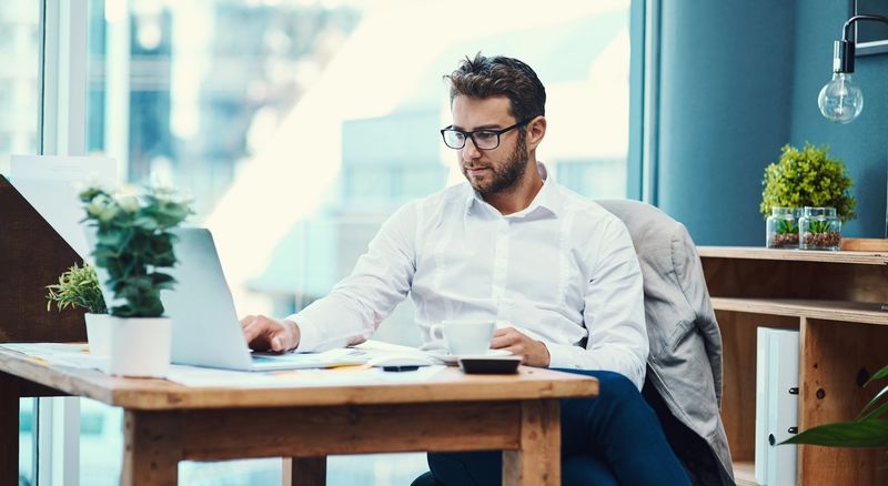 Employer reviewing screening documents on a laptop at a desk