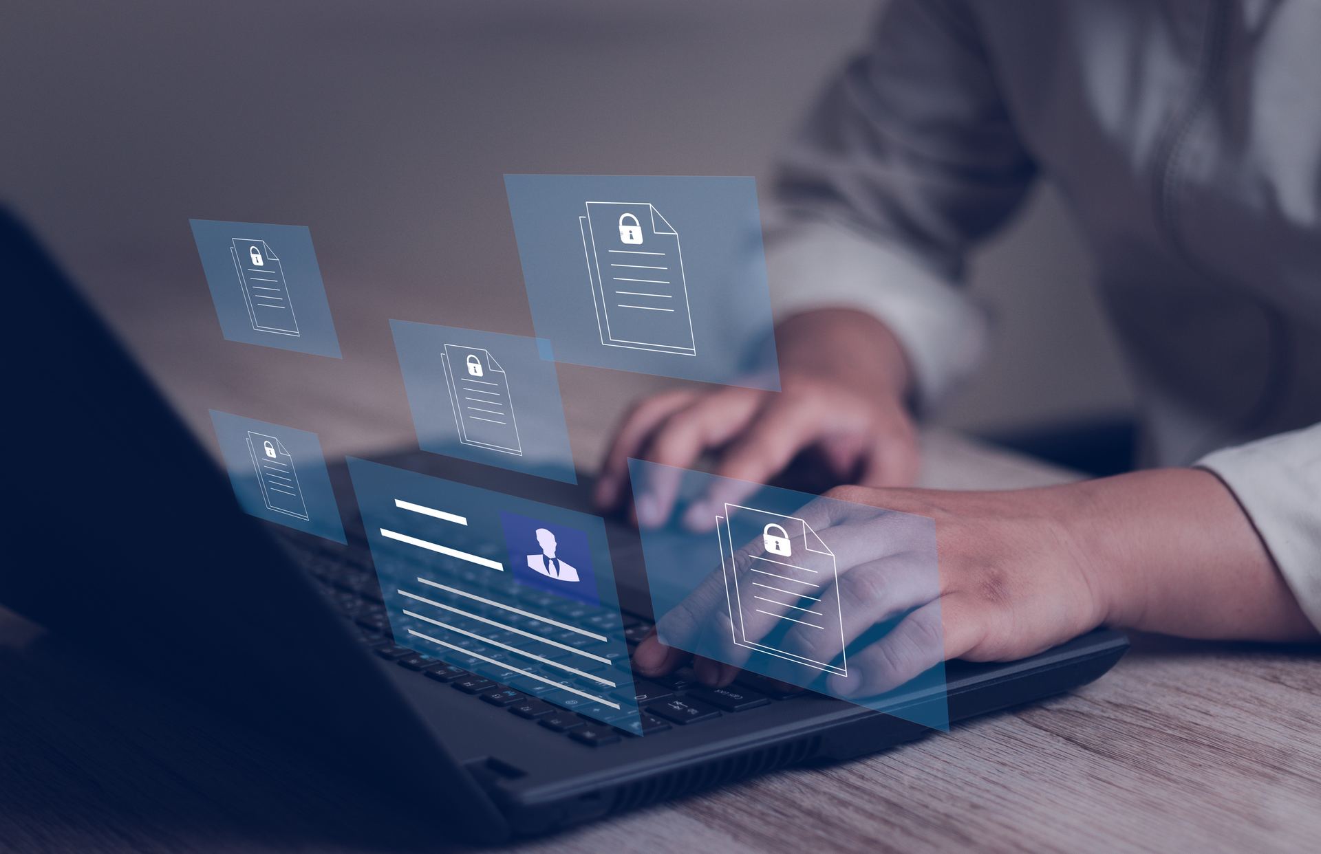 Person using a laptop with secure candidate documents and profile records displayed above the keyboard