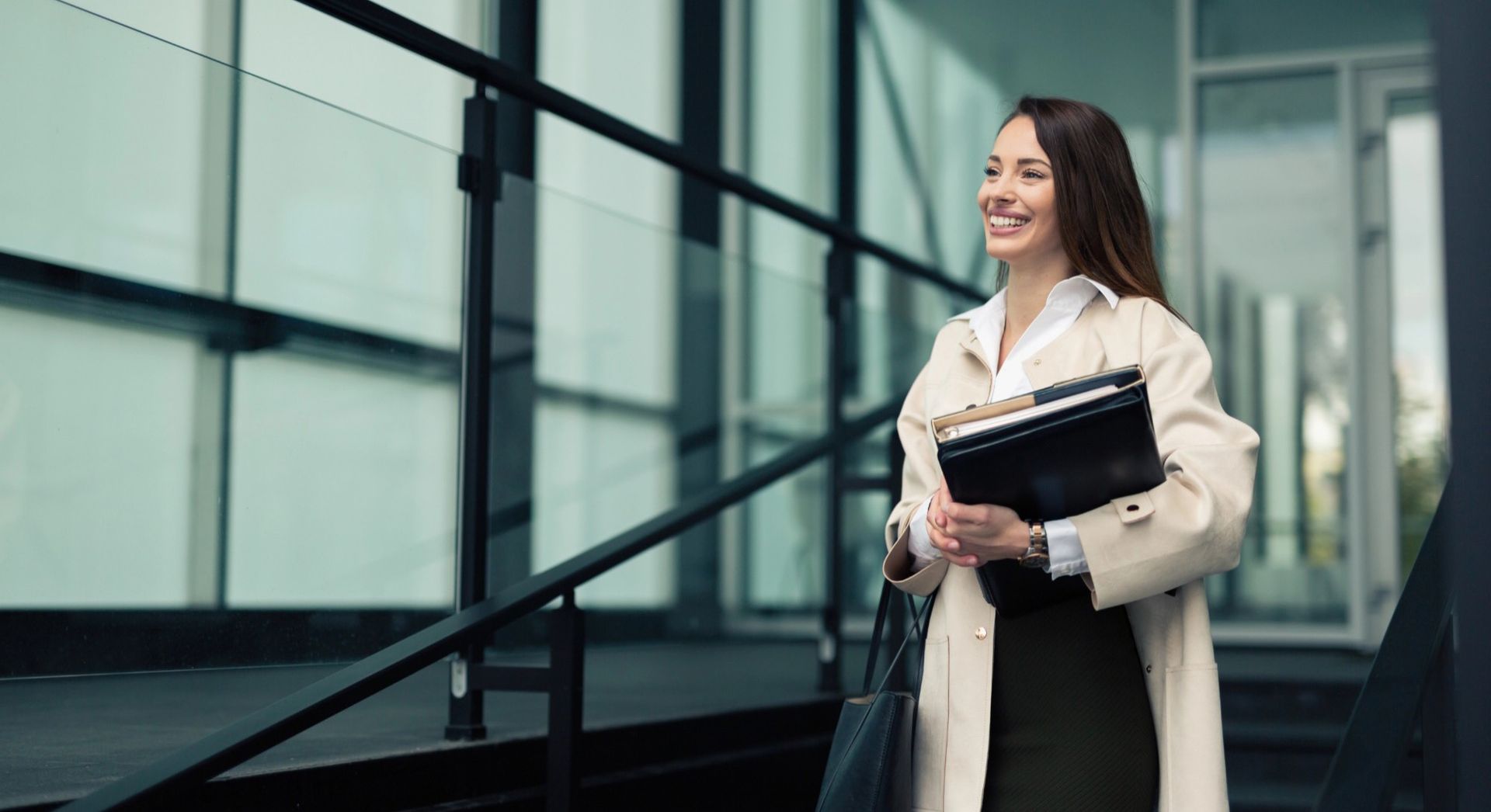 Professional arriving for her first day at work holding a folder of documents